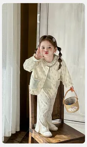 Detailed view of baby girl three-piece spring set with floral jacket and flared pants