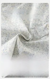 Detail of soft cotton baby outfit with blue floral pattern and button closure