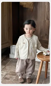 Detailed view of baby boy corduroy vest with striped shirt and brown joggers set