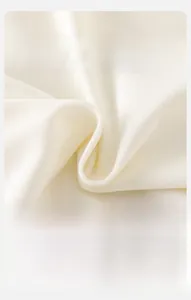 Close-up of soft white knit fabric with fine vertical texture and breathable quality