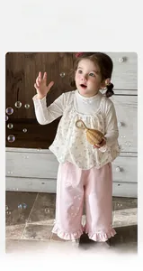 Detail of floral baby girl camisole with pink waffle knit ruffle leg trousers