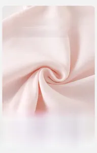 Gros plan sur le tissu en maille côtelée rose pour bébé montrant la texture douce et aérée