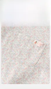 Dettaglio della salopette floreale per neonata con tasca, stemma carota e fiore in tulle 3D