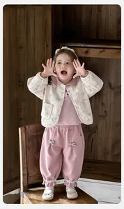 Detailed view of baby girl three-piece floral quilted cardigan set with pink pants