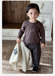 Detail of baby boy autumn 3-piece set with brown cartoon tee and plaid trousers