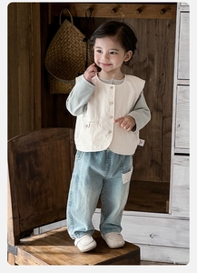 Detail of baby boy retro three-piece set with vest, grey top and denim pants on a model