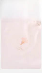 Détail du haut rose pour bébé avec col à volants et imprimé floral élégant