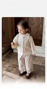 Dettaglio di un top floreale vintage per bambina con pizzo e pantaloni morbidi coordinati