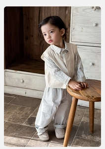 Détail d'un ensemble 3 pièces pour garçon avec gilet beige, chemise et pantalon