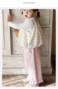 Detail of floral ruffle top and pink trousers with bow accents for baby girls