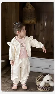 Dettaglio della giacca con cappuccio floreale e t-shirt con orsetto per bimba in rosa e crema