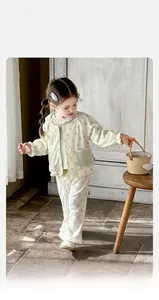 Detail of floral waffle knit cotton set with lace collar for baby girls in cozy home setting