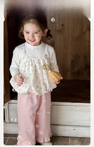 Detail of baby girl floral 3-piece set with white shirt, floral vest and pink ruffled pants