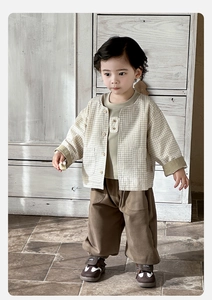 Dettaglio cardigan vintage a quadretti per bambini, t-shirt verde e pantaloni di cotone