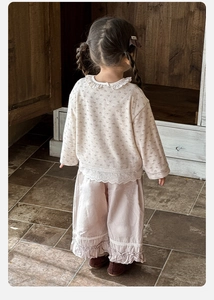 Vista posteriore di top a fiori e pantaloni rosa con orlo in pizzo per bambina