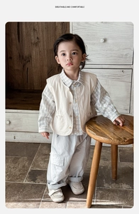Détails d'une tenue vintage pour garçon avec gilet beige, chemise et pantalon cargo gris