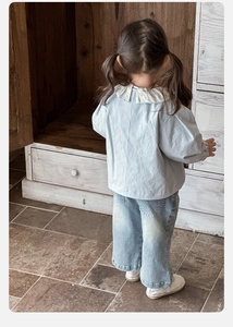 Dettaglio della giacca in cotone blu e jeans a gamba larga per un set primaverile alla moda