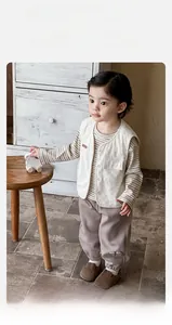 Detail view of baby boy's three-piece set with corduroy vest and bear embroidery pants