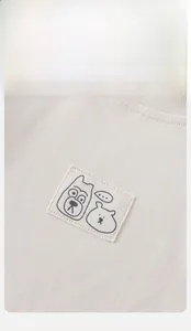 Détail du haut pour bébé en coton avec broderie d'animaux et texture en maille douce