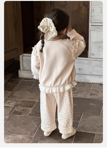Vista posteriore del completo primaverile per bambina con pizzo e fiori