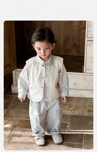 Détail de l'ensemble trois pièces pour bébé avec gilet, chemise et pantalon
