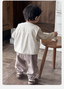 Detailed view of baby boys corduroy vest with striped shirt and brown joggers set