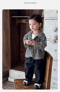 Detail view of baby boy three-piece set with checkered shirt and black casual trousers