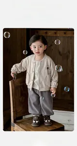 Détail d'un ensemble cardigan beige et pantalon pour bébé avec broderie chien