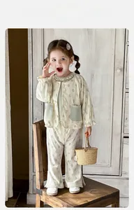 Detail of floral infant set featuring ruffled collar and lace trim on flared trousers