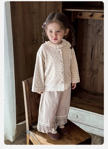 Dettaglio del set floreale in cotone per bambine con pizzo bianco e pantaloni arricciati