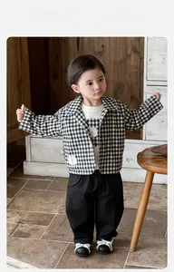 Detail of baby boy retro casual outfit featuring plaid jacket and bear print t-shirt
