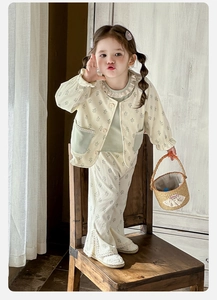 Detail of baby girl floral corduroy set featuring lace trim and vintage wooden buttons