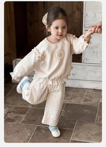 Dettaglio completo floreale neonata con spalle a volant e bordo in pizzo color beige