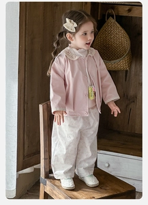 Détail du cardigan rose avec bordure en dentelle et pantalon fleuri pour fille