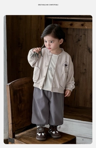 Détail de l'ensemble 3 pièces rétro pour bébé avec veste beige et pantalon gris
