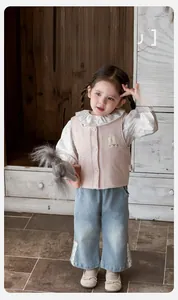 Détail du gilet matelassé rose avec écusson lapin et jean large bordé de dentelle