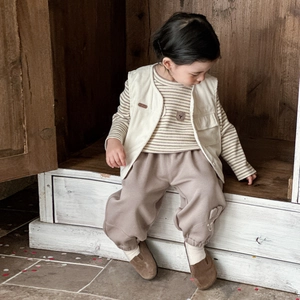 Three-piece boys vintage style set with corduroy vest striped shirt and brown pants