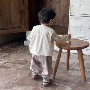 Three-piece toddler boy outfit with corduroy vest, striped tee, and joggers in earth tones