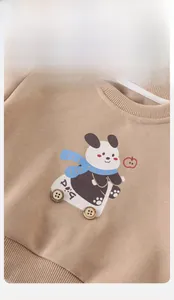 Close-up of boys' camel sweatshirt featuring a cartoon panda and decorative wooden buttons