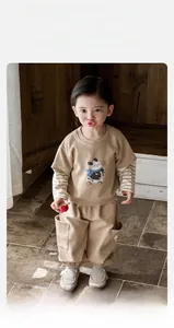 Close-up of kids beige sweatshirt featuring panda illustration and cargo joggers with pockets