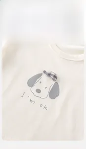 Detail of baby cotton long-sleeved shirt with dog print and 3D plaid hat appliqué