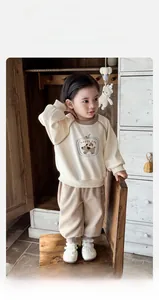 Dettaglio del completo sportivo in cotone beige e cachi per bambino con stampa di cane