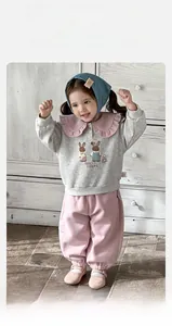 Détail de la tenue bébé fille avec col Claudine rose et texture en coton respirant
