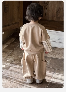 Detail of baby boy oversized khaki sweatshirt with beige striped cuffs and cargo pants