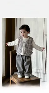 Detail of toddler boy 3-piece set featuring checkered vest and cartoon bear print t-shirt