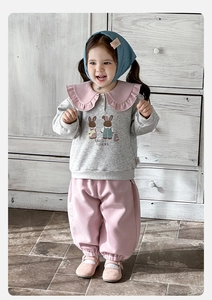 Détail du sweat gris pour bébé fille avec col à volants rose et motif de lapin mignon
