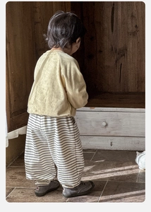 Vista posteriore della felpa gialla per neonati e dei pantaloni a righe stile harem