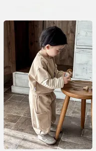 Detail of toddler khaki knit sweatshirt and cargo pants set in a warm home setting