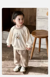 Dettaglio della felpa beige per bambini con cucciolo di cartone animato e testo