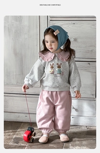 Détail de l'ensemble deux pièces pour bébé fille avec sweat gris et pantalon rose